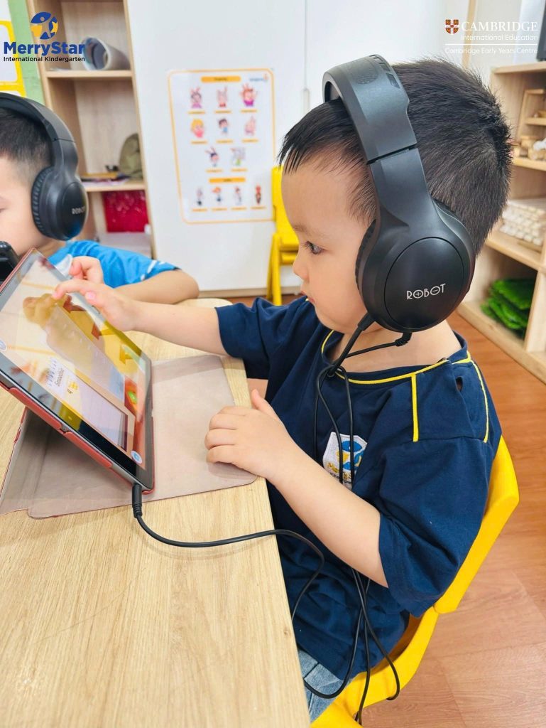 Trẻ mầm non sử dụng iPad và tai nghe trong lớp học